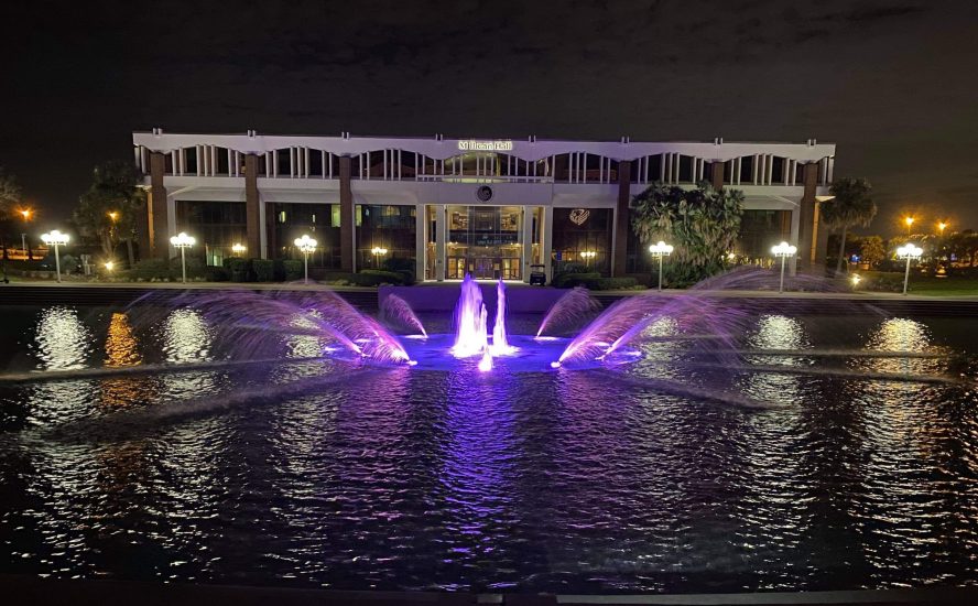 UCF Reflecting Pond lit up at night with purple LEDs