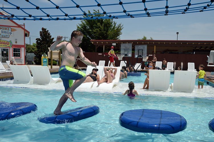 Youth completing the floating lily pad water walk at Hawaiian Falls Roanoke