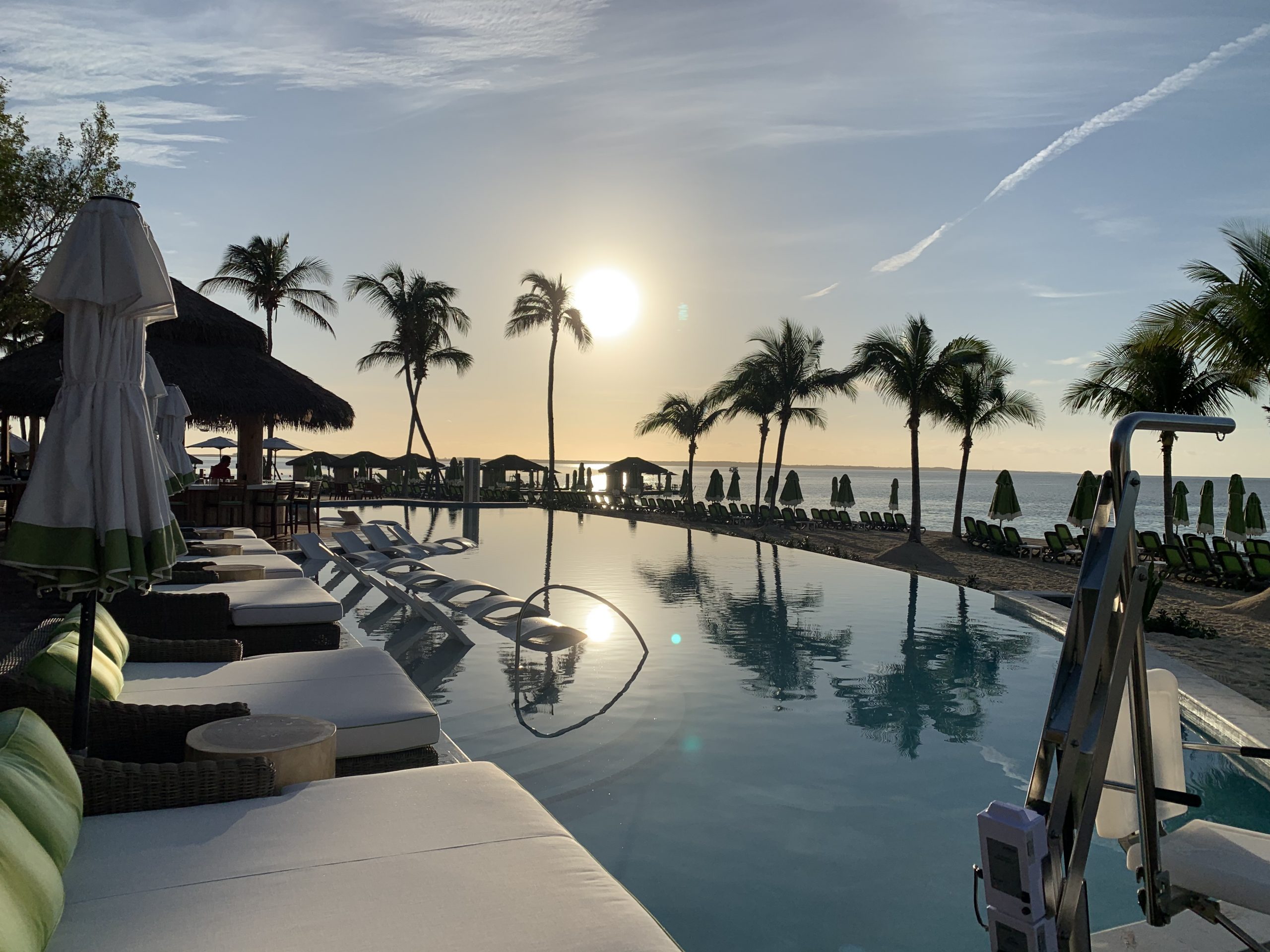 Pool deck, lounge chairs, and sunshelf at Royal Caribbean's Coco Beach Club during sunset